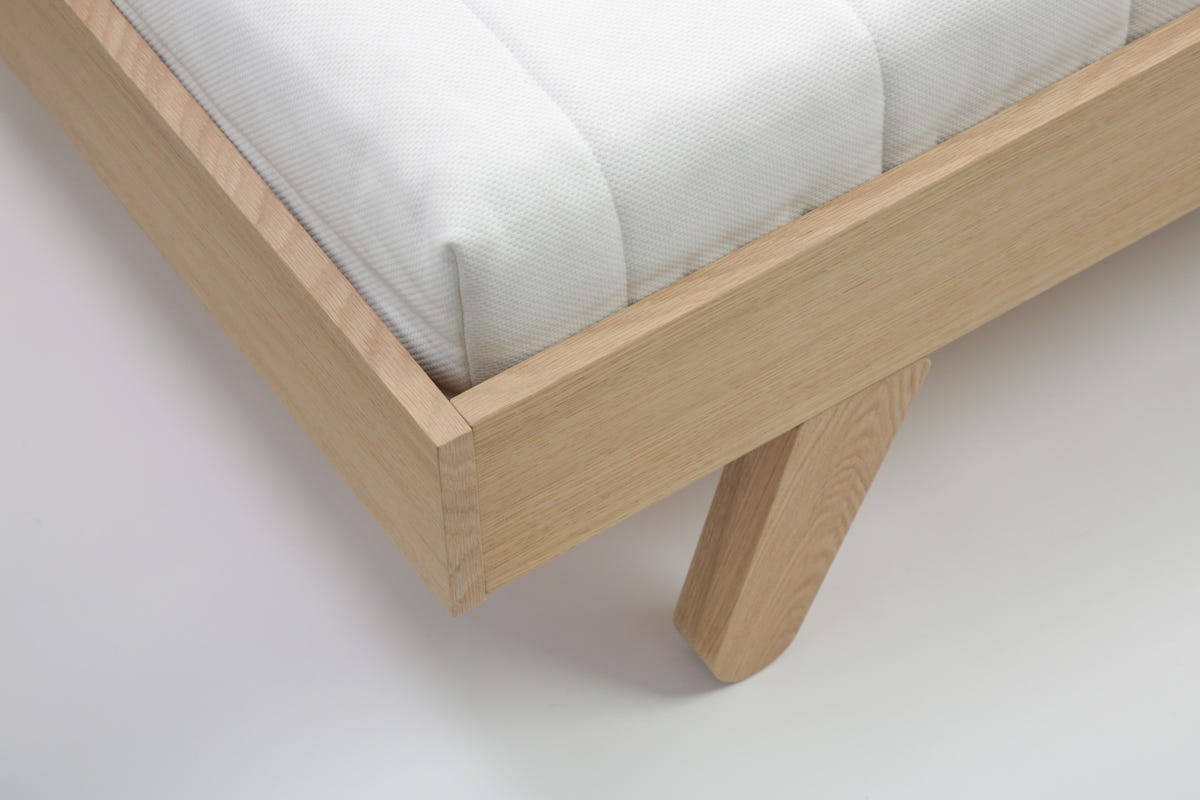 Studio shot of wooden single bed with mattress