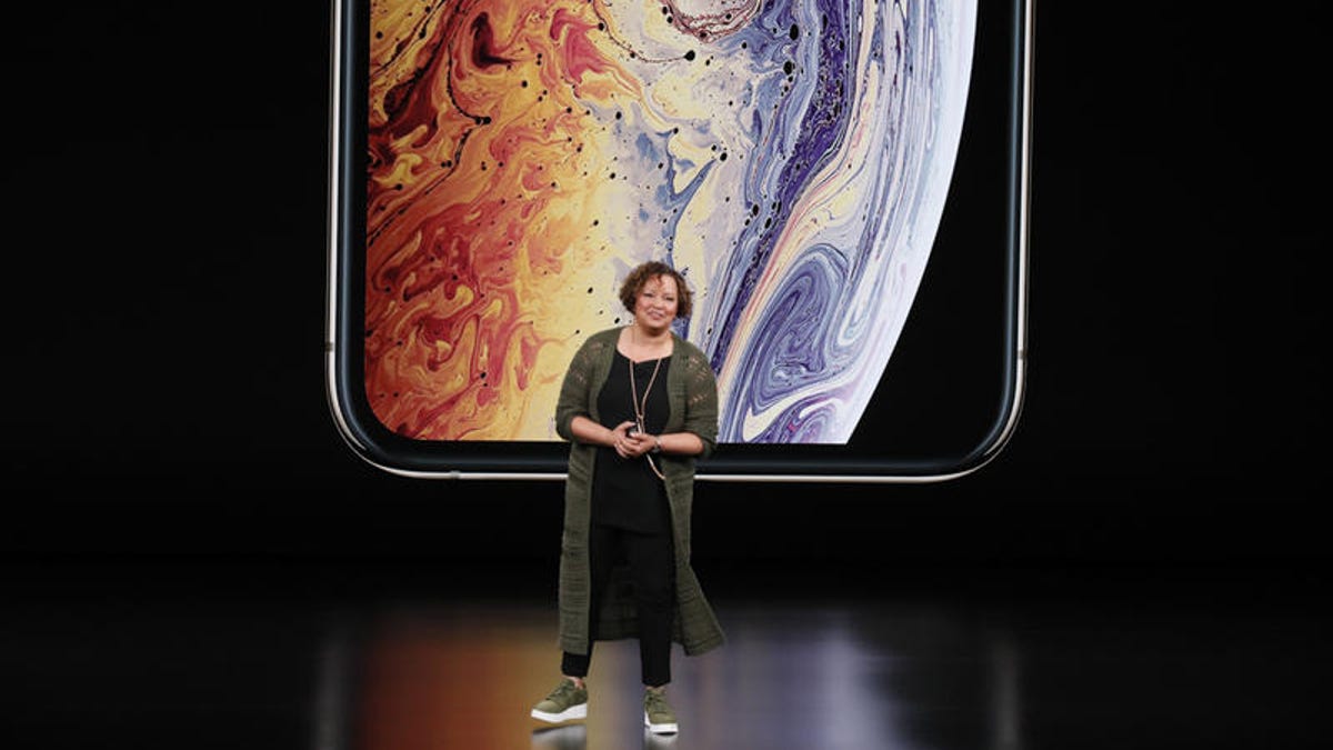 Lisa Jackson stands in front of a projection of an iPhone.