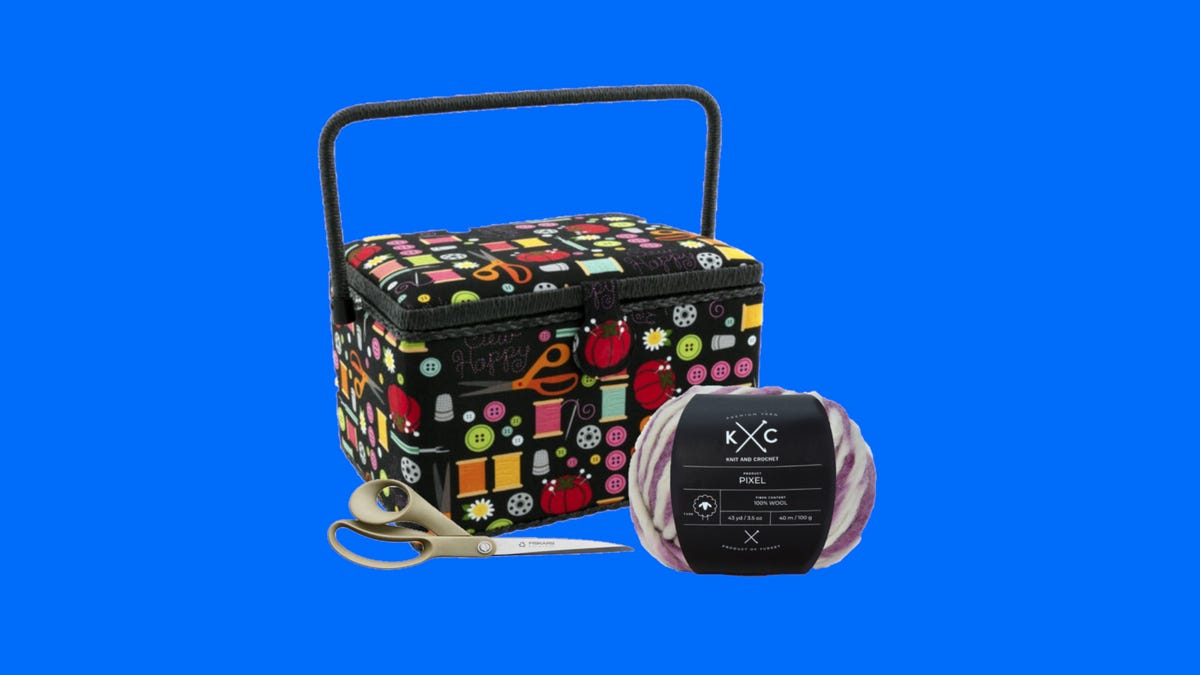 A pair of scissors, yarn and a sewing basket on a blue background