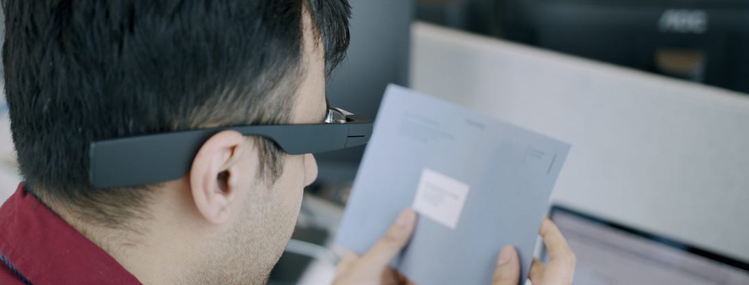 Man wears Envision Glasses to read a letter
