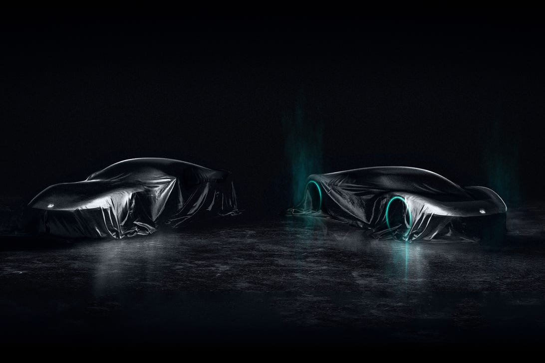 Two black sports cars with lit wheels on a dark background.