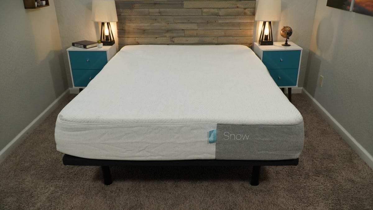 The Casper Snow mattress in between two nightstands and on top of a gray bed frame.