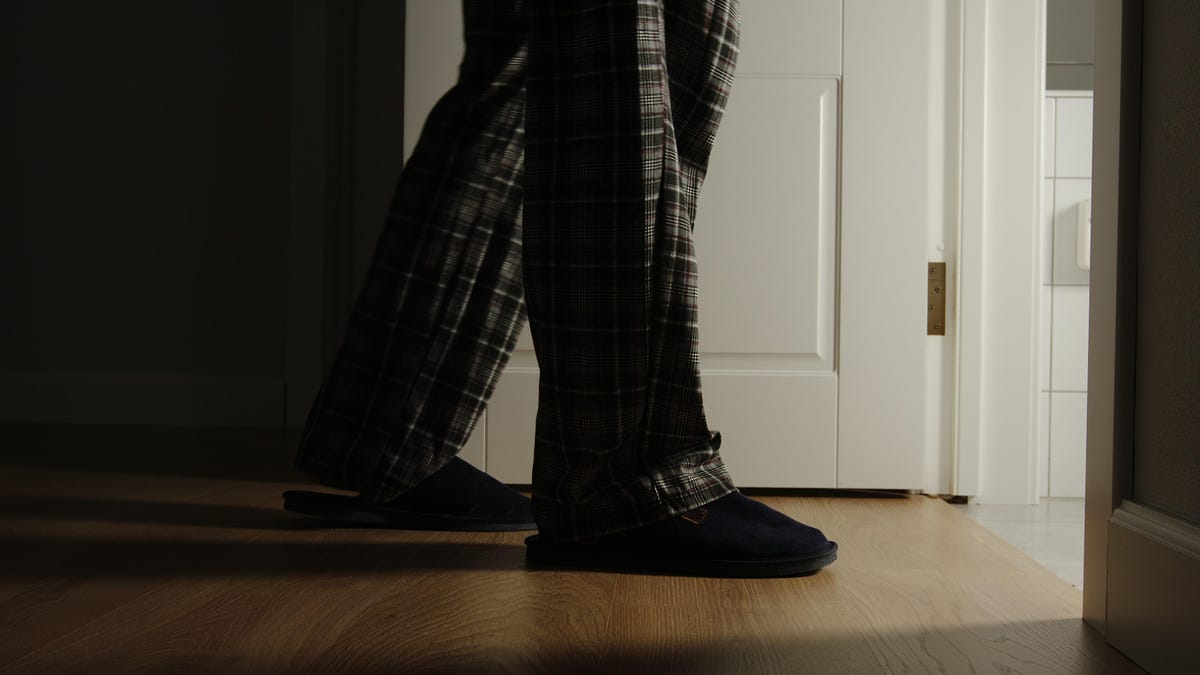 Man in pajamas and slippers walking to the bathroom during the night