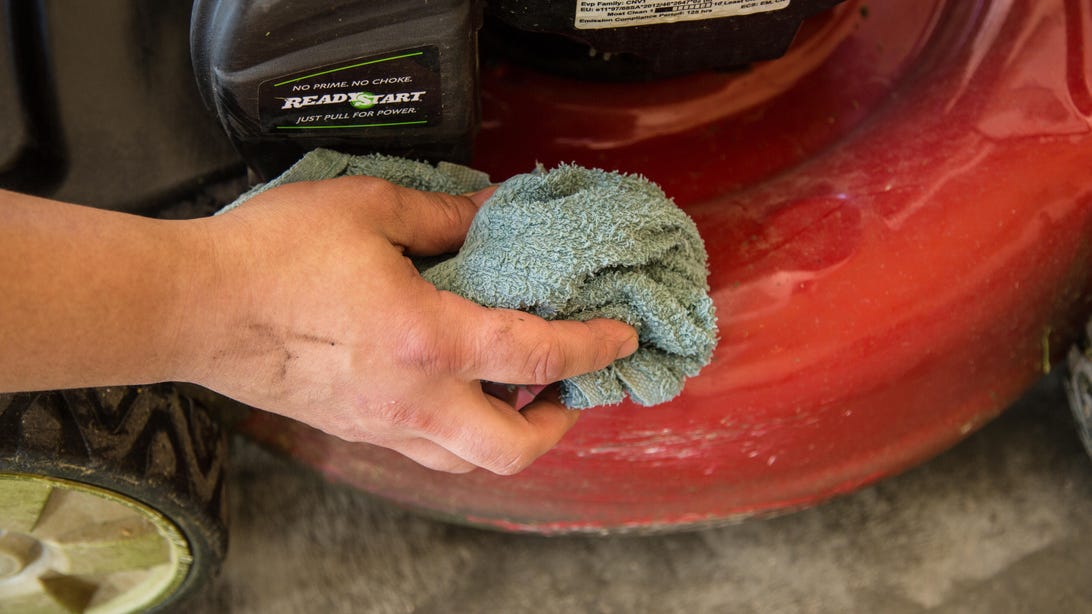 cleaning a lawn mower with a cloth