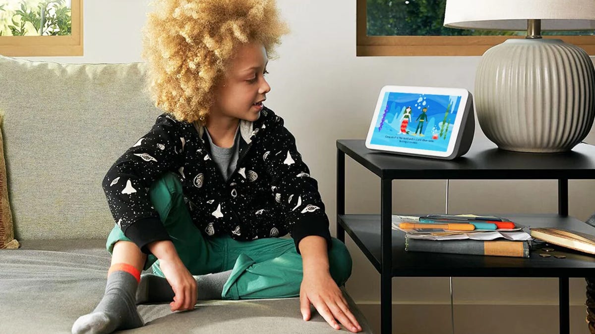 child gazes at Amazon Echo Show device using Alexa create a story feature