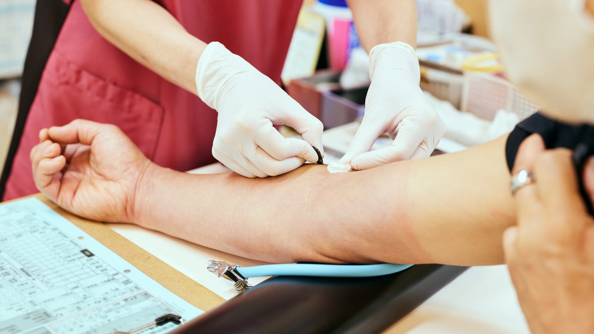 A nurse puts a bandaid on a donor's arm