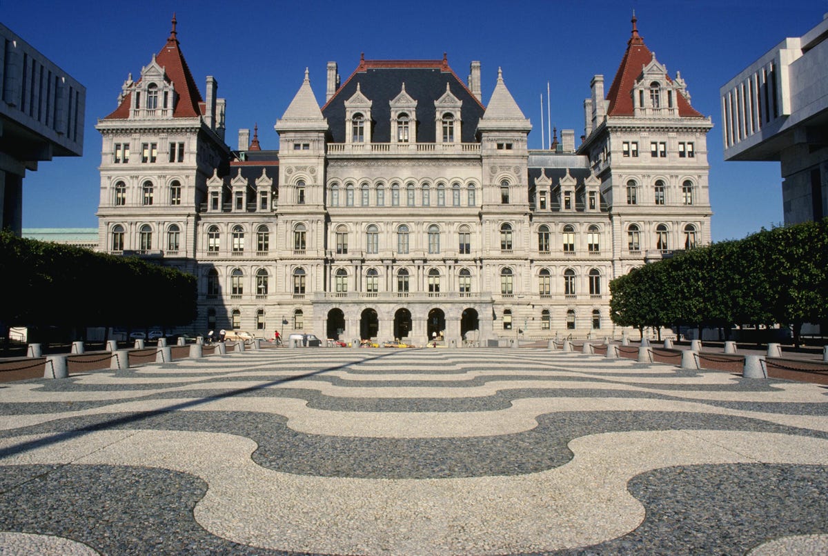 New York State Capitol building in the daytime, with an expansive view of the walkway leading up to the structure.