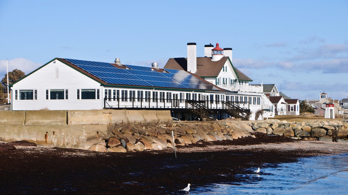 An array of solar panels cover the roof of the dining room of a classic Cape Cod inn in Massachusetts.