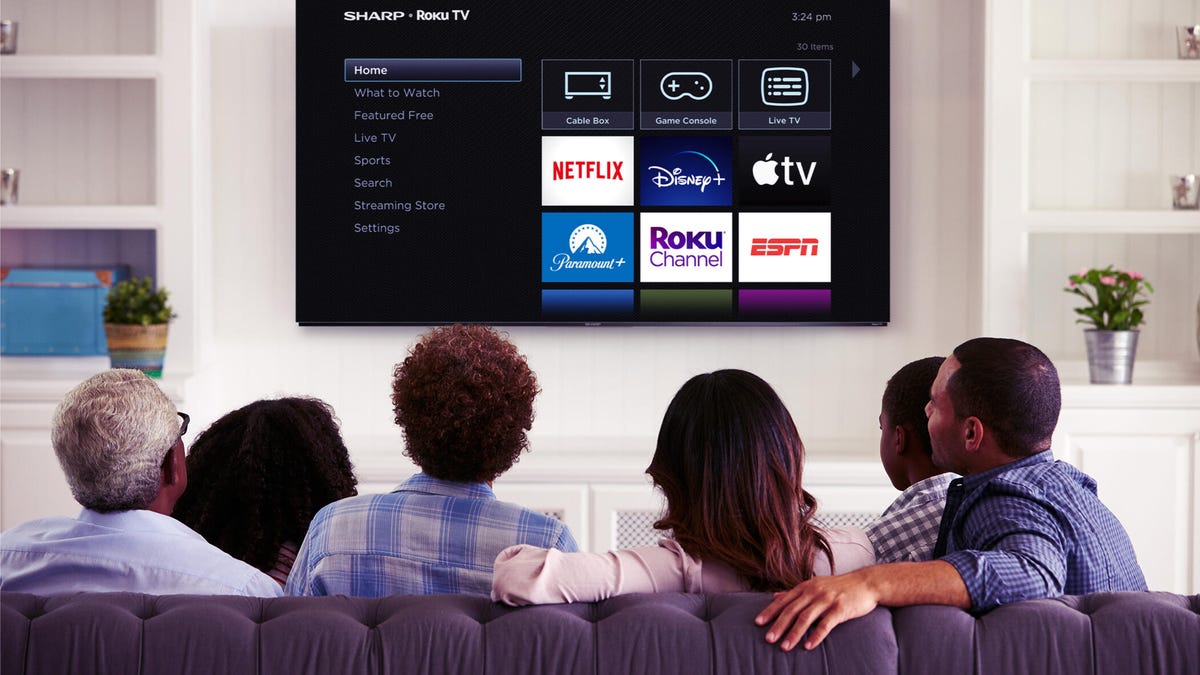 A 2023 Sharp Roku TV being watched by a group of people.