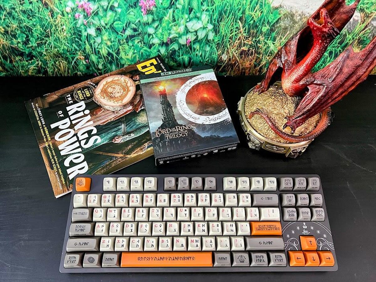The Dwarvish keyboard from Drop, with a Smaug statue and Lord of the Rings Blu-ray