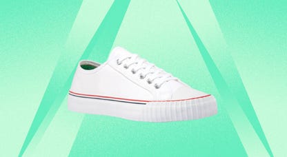 White PF Flyers canvas sneakers are displayed against a mint background.