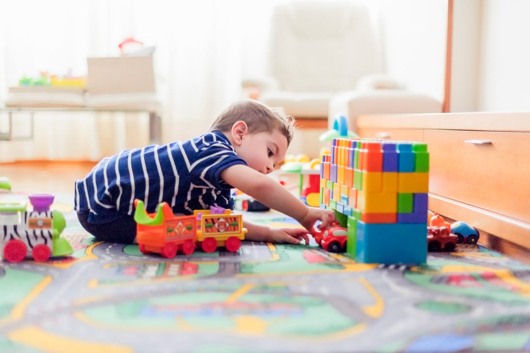 Little boy playing with blocks and toy cars