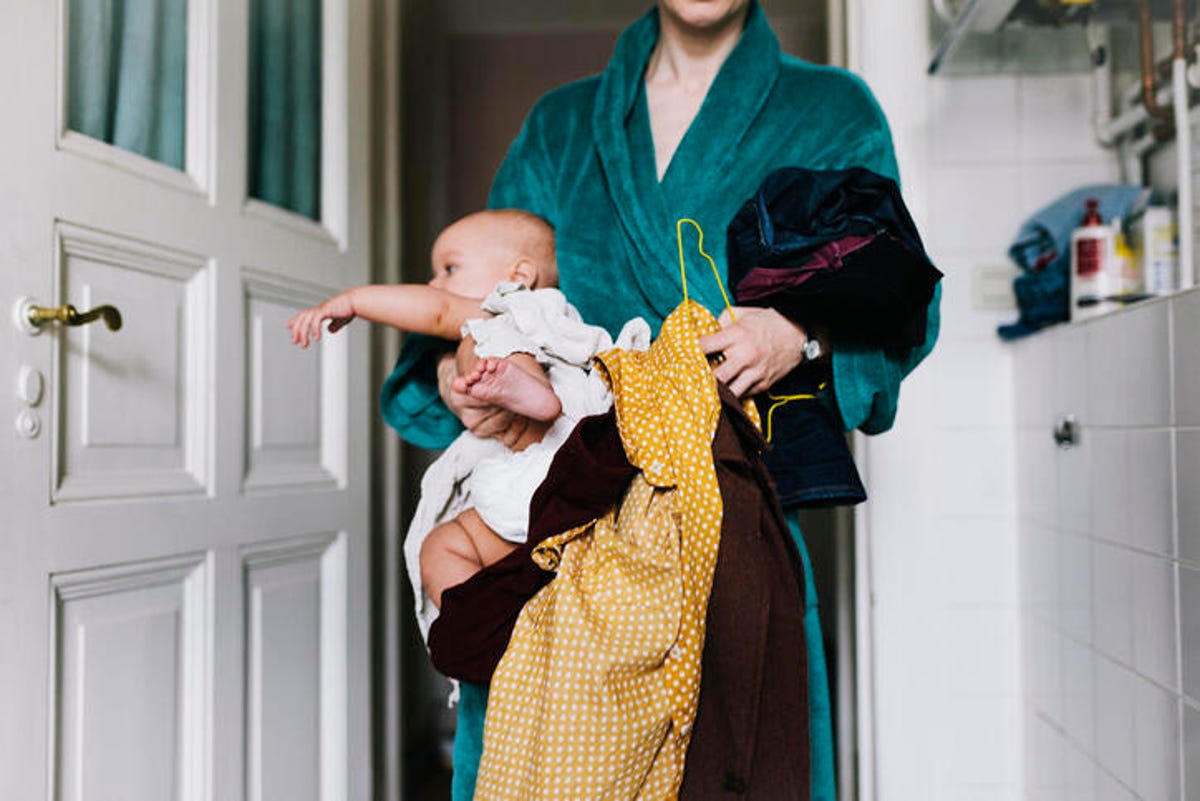 New mom holding baby and clothes