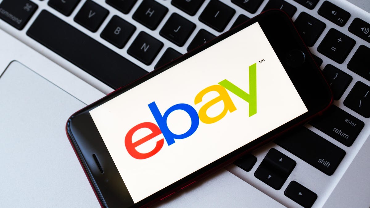 eBay logo on a phone that's lying on a computer keyboard