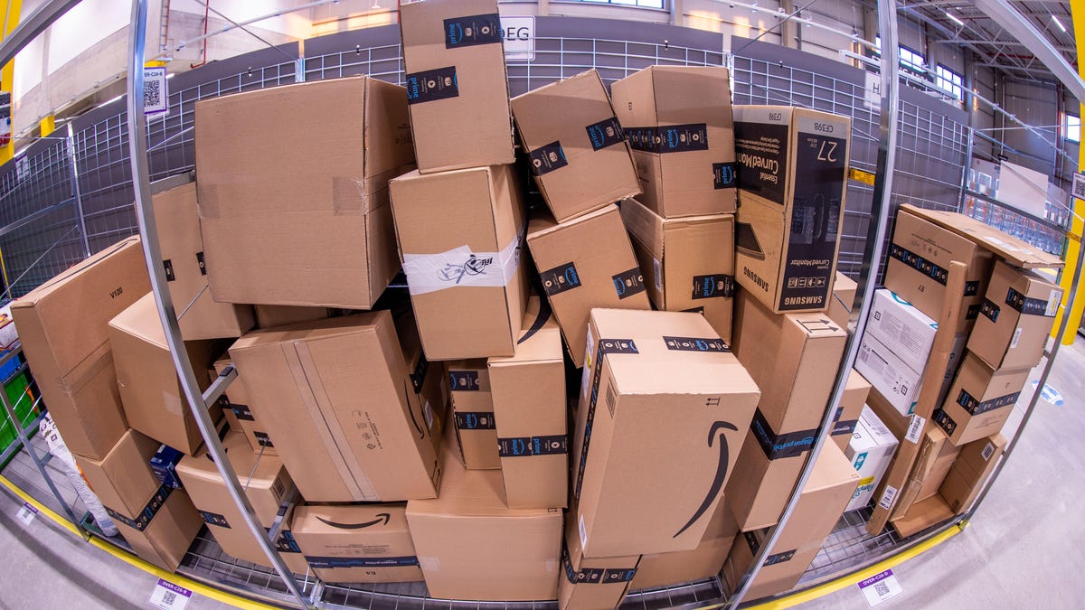 A pile of Amazon boxes reflected in a convex mirror.