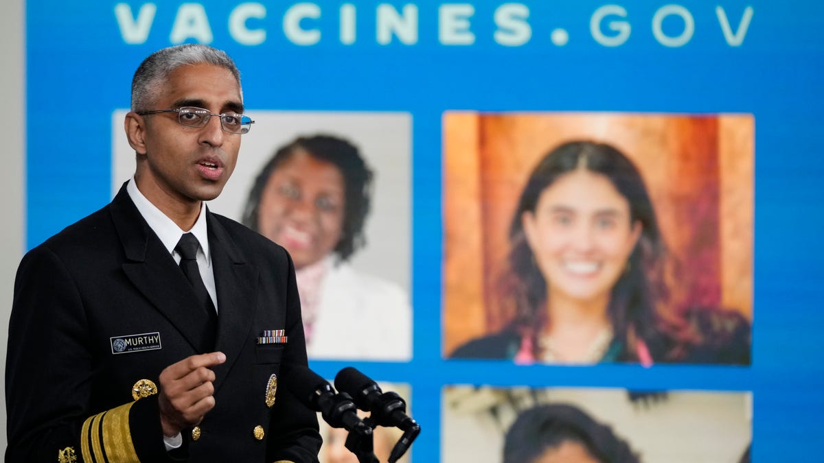 Surgeon General Vivek Murthy in front of a vaccines.gov poster