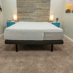 The Casper Nova mattress in between two nightstands and on top of a gray bed frame.