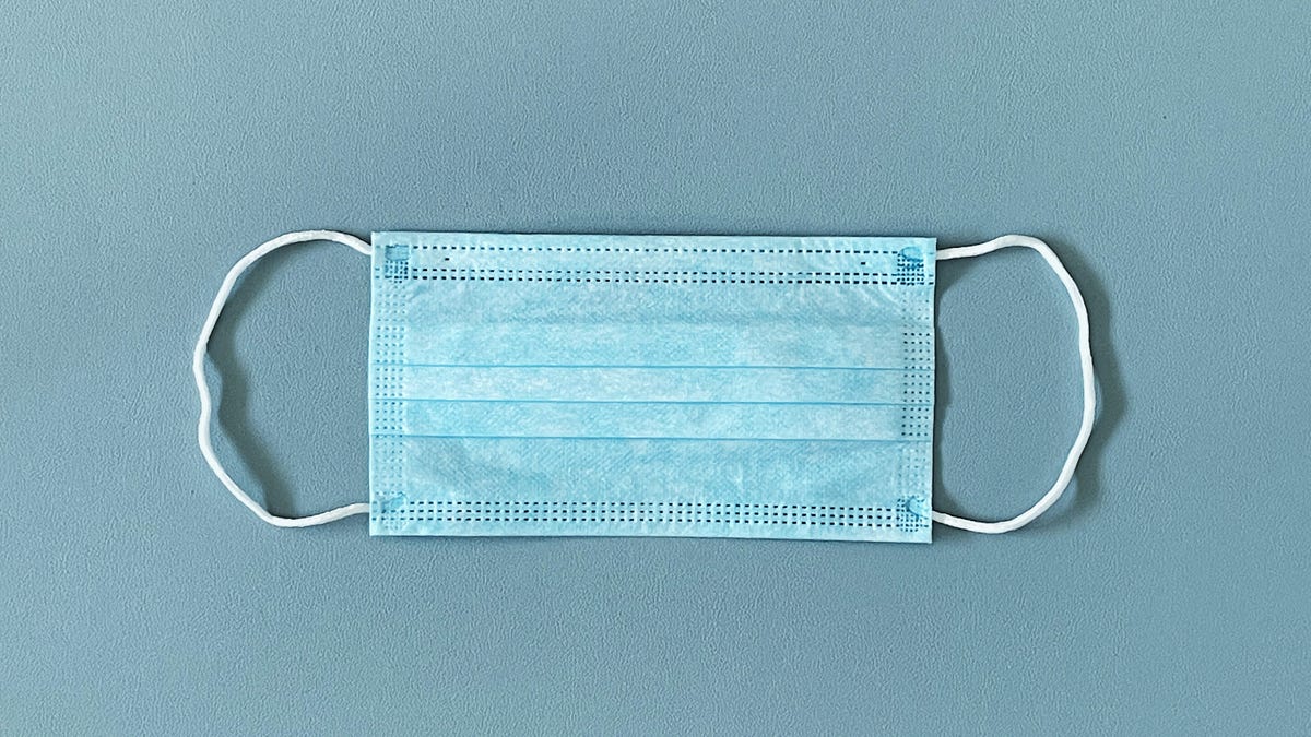 A blue surgical mask on gray background
