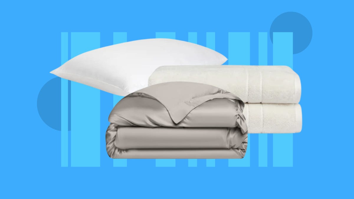 A duvet cover, two towels and a pillow from Cozy Earth are displayed against a blue background.