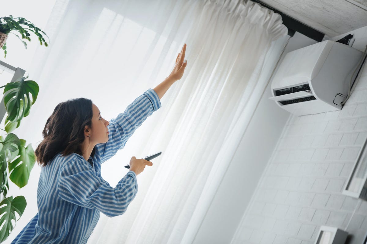 Woman turning on air conditioning