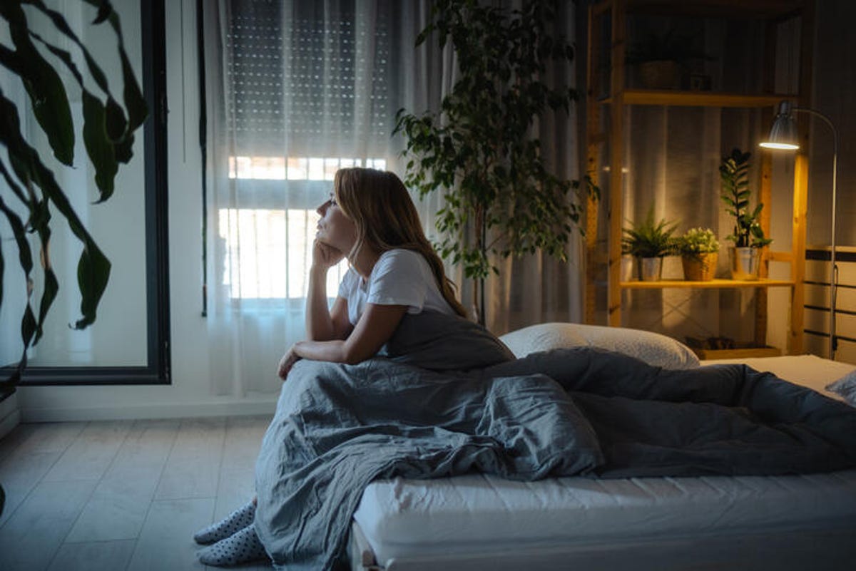 Woman sitting on the edge of her bed