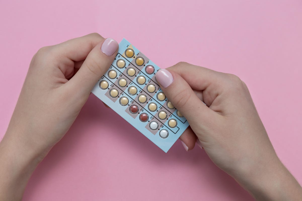 Close up of hands holding birth control pills