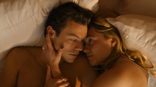 Harry Styles and Florence Pugh cuddle in bed in the movie Don't Worry Darling.