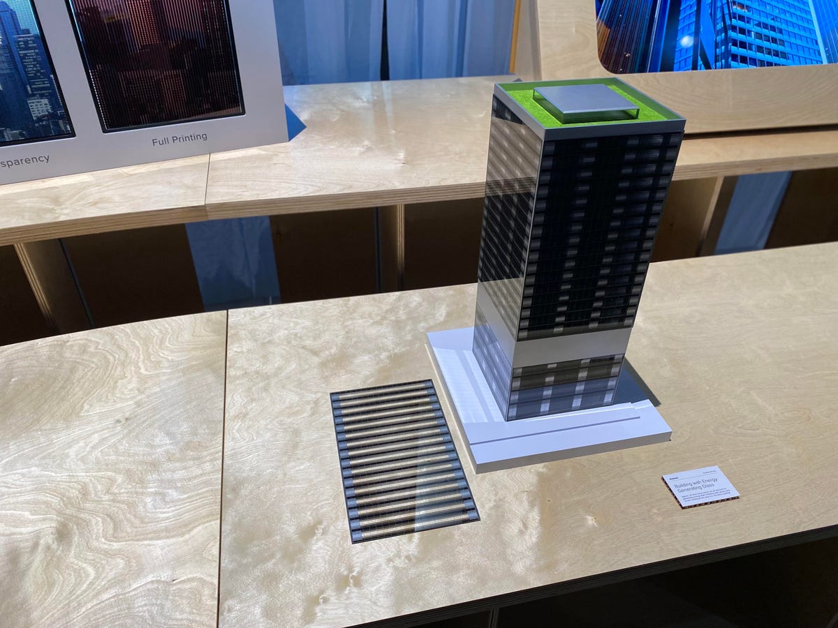 A model of a skyscraper with black lines on the windows representing potential perovskite solar cells.