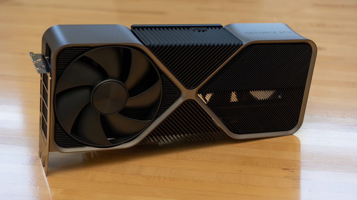 The Nvidia GeForce RTX 4080 FE sitting upright, angled to accommodate the connector, showing the back of the card on a wood table