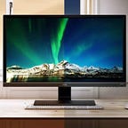 BenQ EW3270U display on a desk with a keyboard and mouse