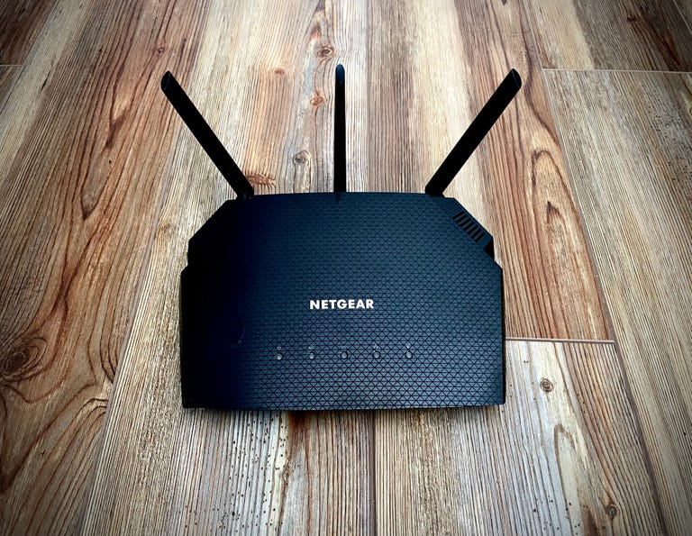 Netgear wi-fi router on a wooden floor.