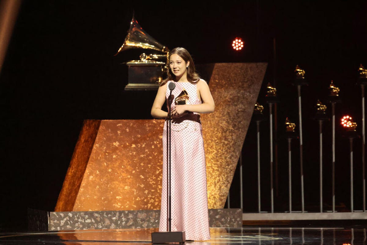 Laufey holding her Grammy award onstage at the 2024 Grammys ceremony