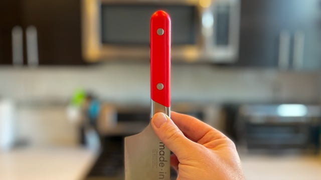 Made In knife handle held up in front of kitchen