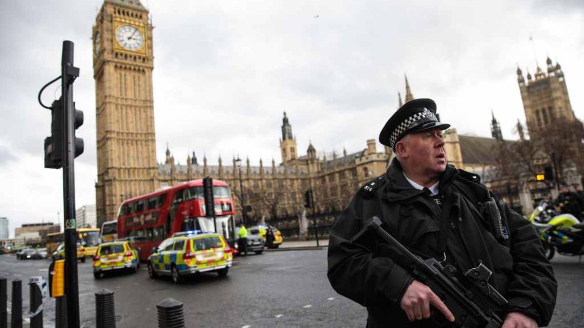 An armed police officer stands guard near Westminster Bridge and the Houses of Parliament following the incident.