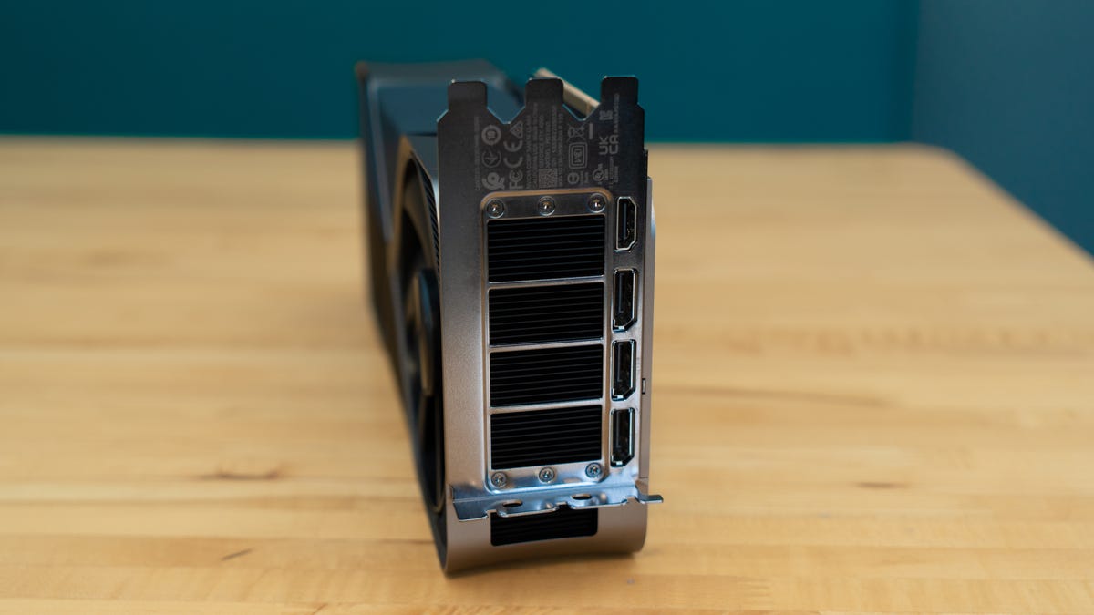 Nvidia GeForce RTX 4090 Founders Edition sitting on a wood table, bottom up, with the connectors and vents facing you