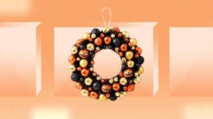 A Halloween bauble wreath is displayed against an orange background.