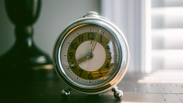 a vintage alarm clock on a nightstand