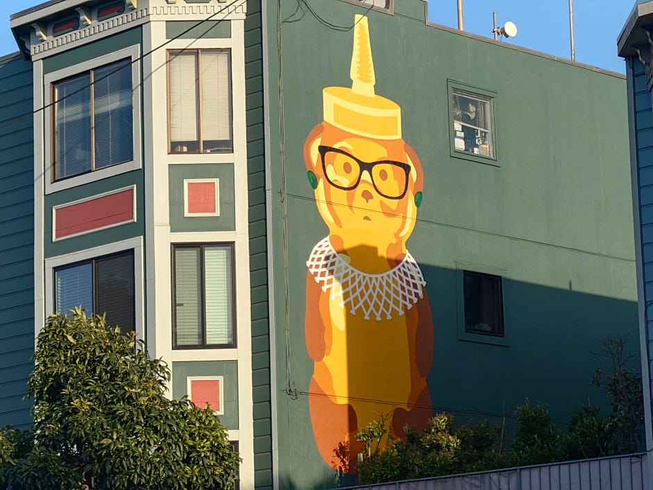 Photo d'une bouteille de miel géante et de Ruth Bader Ginsburg peinte sur un bâtiment