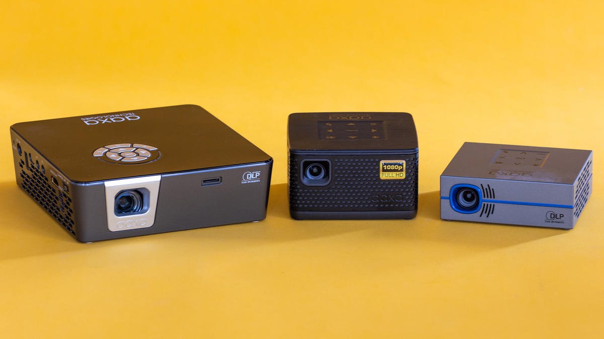 Three AAXA pico projectors on a yellow background.