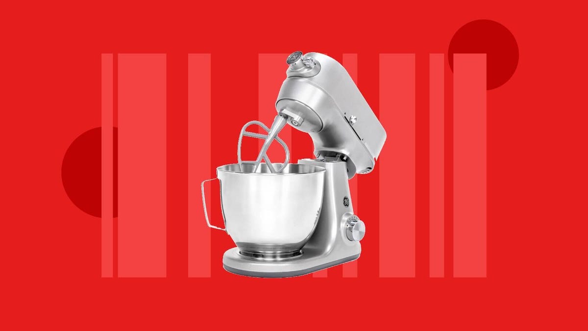 A silver GE stand mixer and bowl against a red background.