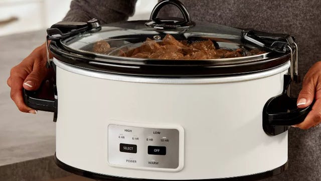 person holding crock pot with beef stew inside