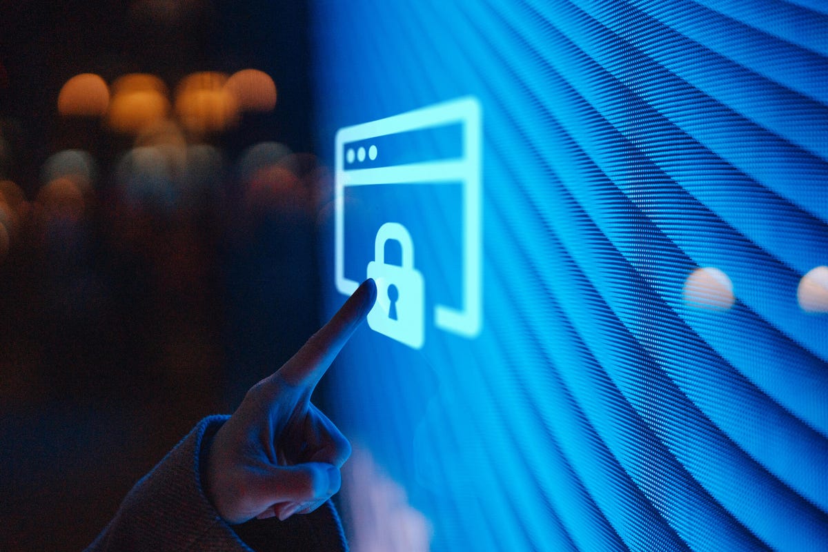 A finger reaches out to touch a lock icon on a blue screen.