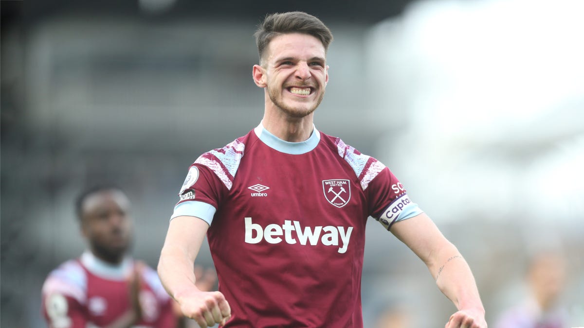 West Ham United midfielder Declan Rice smiling with clenched fists in front of him.