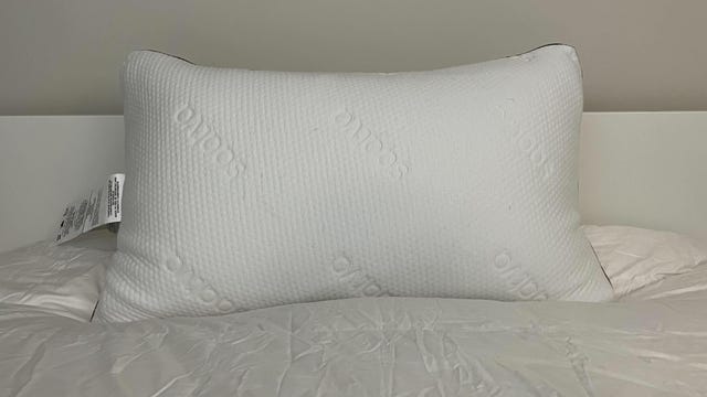Saatva Graphite Memory Foam Pillow on a white bed.