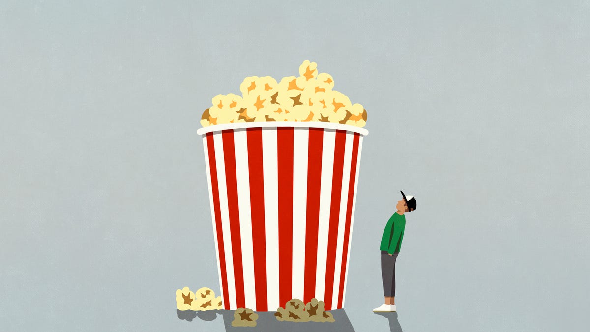 Illustration of person looking up at a gigantic striped container of popcorn