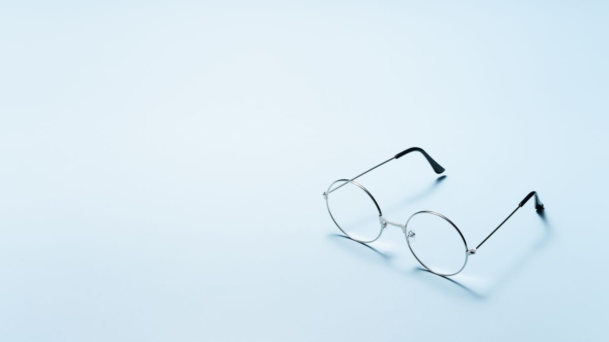 Round glasses on a light blue background.