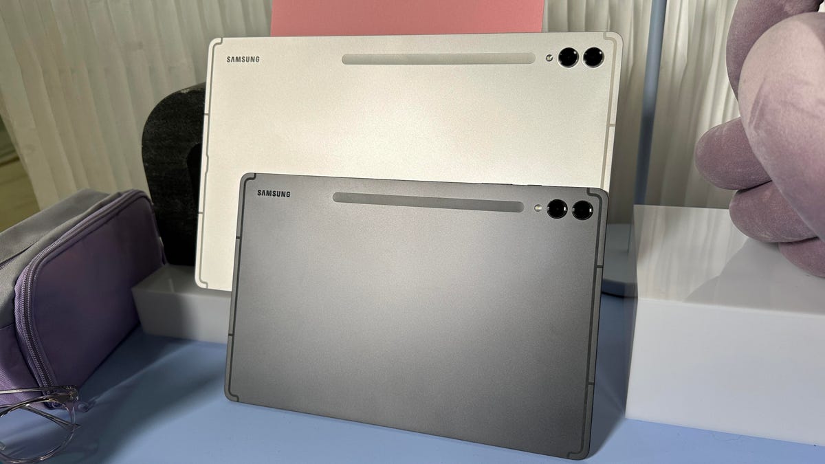 The backs of two metal tablets, resting on a table as they stand up to show the size differences