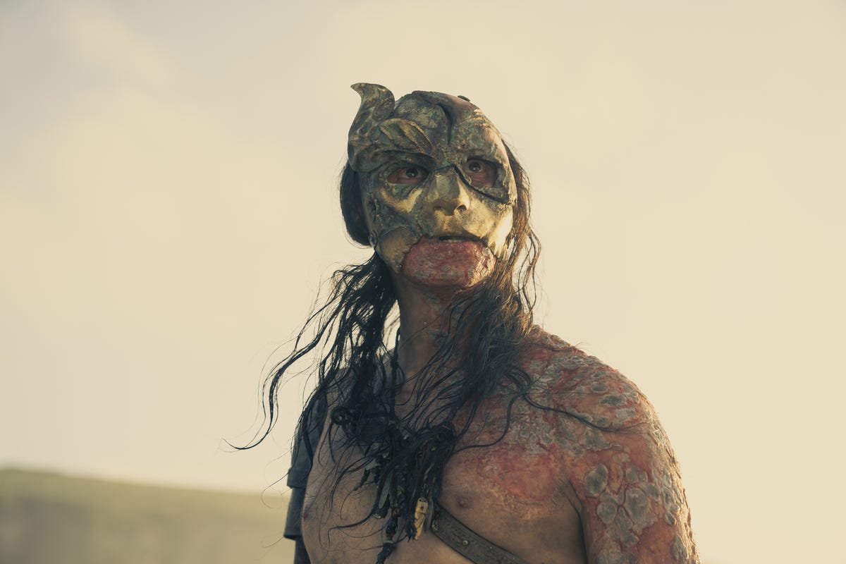 The Crabfeeder, with stringy hair and barechested, wearing a mask