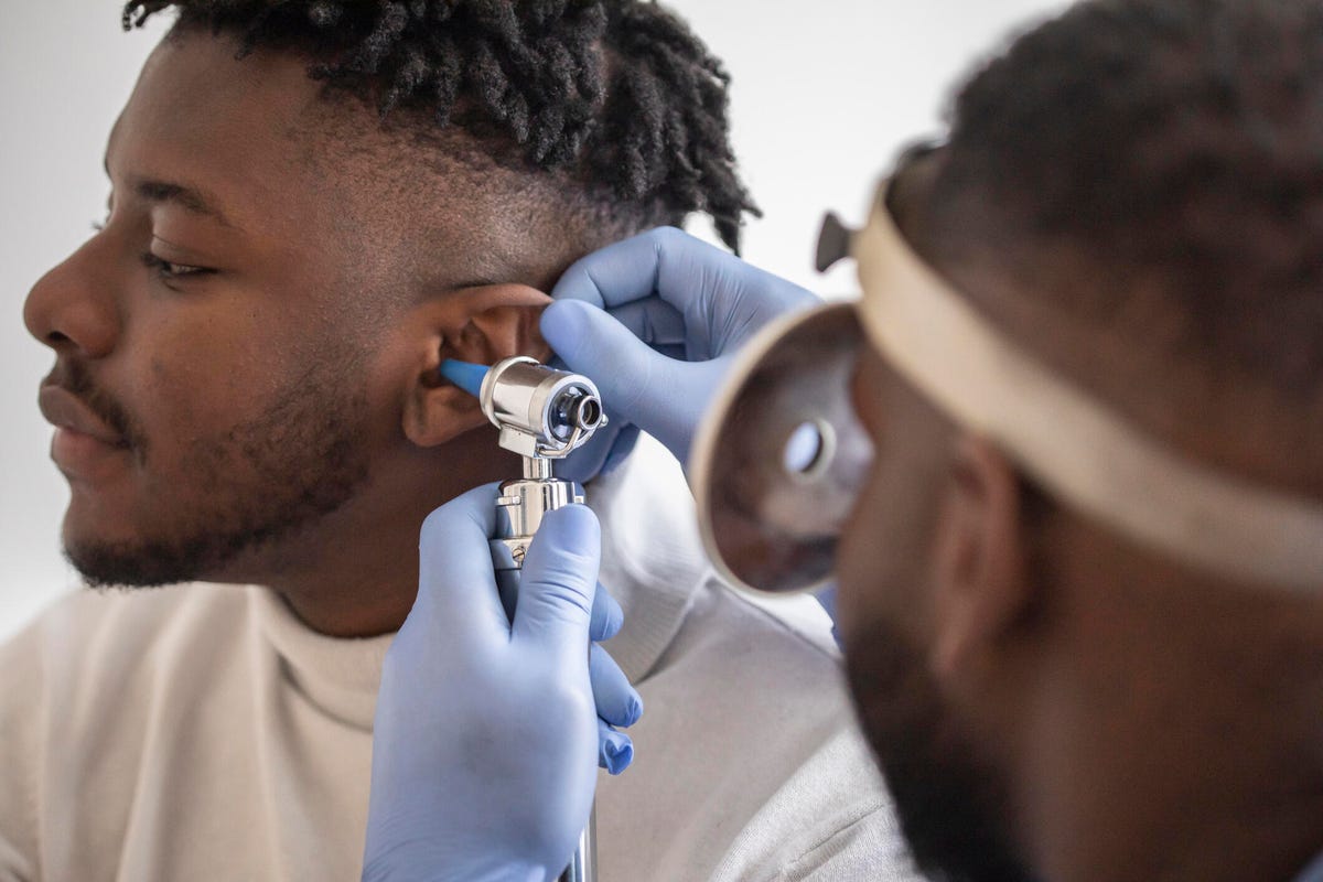 Close up of a doctor checking the ear of his male patient.