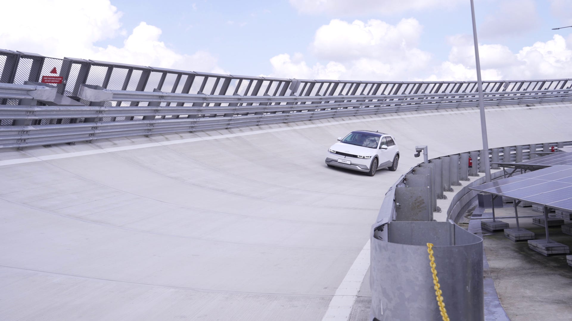 an Ioniq 5 rounds the corner of the rooftop test track 